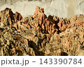 A geological feature with a rugged surface and distinct details, composed of alternating layers of reddish-brown and beige rock. 143390784