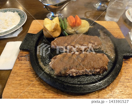 鉄板で提供されたジューシーなハンバーグの洋食料理 鉄板で提供されたジューシーなハンバーグの洋食料理 143391527