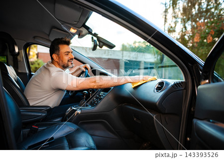 Man cleaning car dashboard with microfiber cloth Man cleaning car dashboard with microfiber cloth 143393526