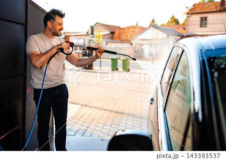 Man washing car with pressure washer at self-service car wash Man washing car with pressure washer at self-service car wash 143393537