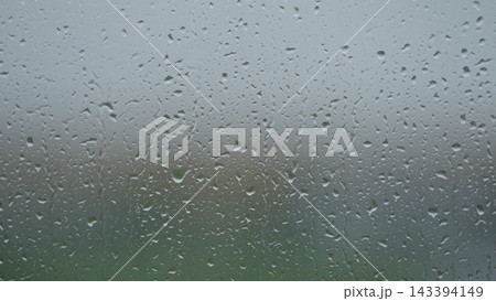 Rain drop hitting window glass and sliding down Rain drop hitting window glass and sliding down 143394149