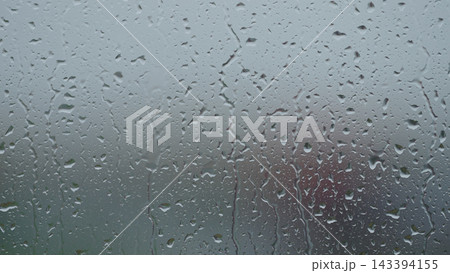 Rain drop hitting window glass and sliding down Rain drop hitting window glass and sliding down 143394155