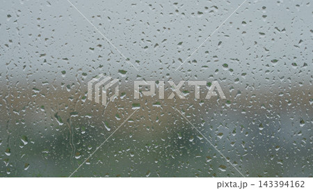 Rain drop hitting window glass and sliding down Rain drop hitting window glass and sliding down 143394162