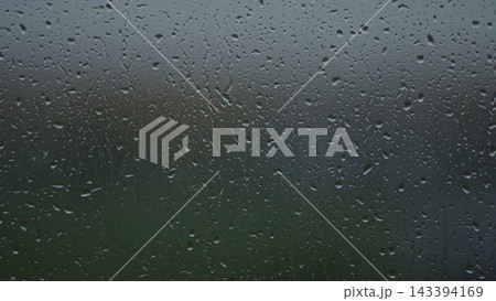 Rain drop hitting window glass and sliding down Rain drop hitting window glass and sliding down 143394169
