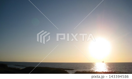 快晴の青空と海に沈む夕日と 143394586