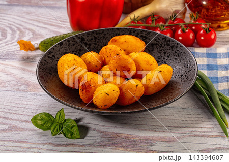Rustic wooden table with roasted baby potatoes in dark ceramic bowl, fresh tomatoes, paprika, cucumber and basil around, homemade vegetarian food Rustic wooden table with roasted baby potatoes in dark ceramic bowl, fresh tomatoes, paprika, cucumber and basil around, homemade vegetarian food 143394607