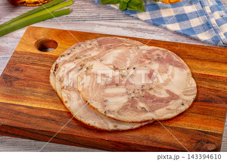 Green onions and checkered cloth beside sliced mortadella with pepper on rustic wooden cutting board, Italian cold meat delicatessen 143394610