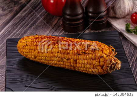 Grilled corn on the cob with spices on a black plate 143394638