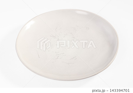 Empty white ceramic plate with faint scratches and scuff marks on glazed surface, isolated on white background, tableware wear and kitchenware condition concept 143394701