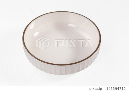Brown rimmed ceramic ramekin, white fluted bowl, kitchen tableware Brown rimmed ceramic ramekin, white fluted bowl, kitchen tableware 143394712