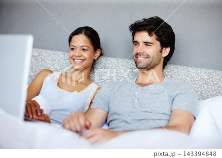 Happy couple, relax and watching with laptop in bed for online streaming, subscription or movie at home. Man and woman with smile together for morning, show or series on computer in bedroom at house 143394848