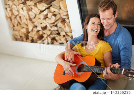 Couple, guitar and happy for music on floor in home with bonding, connection and art in living room. Man, woman and musician with teaching, listen and creativity with instrument on carpet in house 143396256