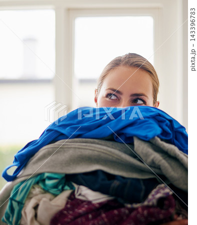 Woman, cleaning and peek with laundry basket, organizing clothes and apparel washing in kitchen. Lady, fabric bundle and housekeeping hygiene with clothing during morning chores routine in lounge Woman, cleaning and peek with laundry basket, organizing clothes and apparel washing in kitchen. Lady, fabric bundle and housekeeping hygiene with clothing during morning chores routine in lounge 143396783