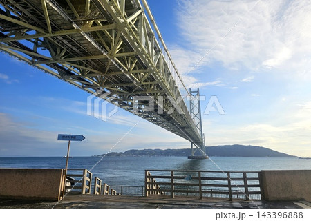 Low Angle View of Akashi Kaikyo Bridge Steel Truss Structure Extending Over Sea Toward Awaji Island in Hyogo, Japan Low Angle View of Akashi Kaikyo Bridge Steel Truss Structure Extending Over Sea Toward Awaji Island in Hyogo, Japan 143396888