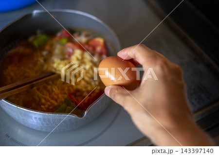 インスタントラーメン作り_卵を入れる 143397140