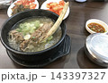 骨付き肉が入った熱々のスープとキムチが並ぶ韓国料理の食卓 143397327