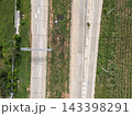 Top down drone aerial view of divided highway with road markings and sugarcane plantation 143398291