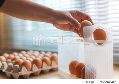 Hand Selecting Fresh Chicken Eggs from Egg Cartons Hand Selecting Fresh Chicken Eggs from Egg Cartons 143398307