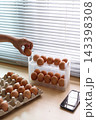 Hand Selecting Fresh Chicken Eggs from Egg Cartons 143398308
