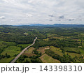 Aerial drone view of Highway winding through lush green mountains between Nan, Thailand. A scenic landscape of the road surrounded by tropical forest and a peaceful countryside 143398310