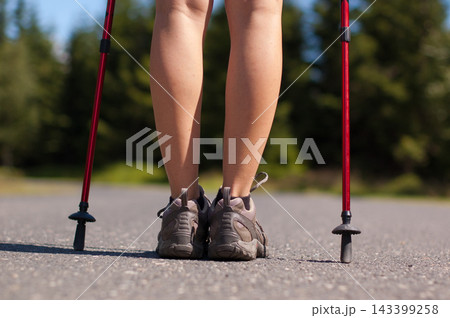 Hiking Legs with Trekking Poles on Outdoor Road Hiking Legs with Trekking Poles on Outdoor Road 143399258