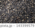 香ばしい炒りごま黒の粒が詰まった、栄養豊富な食材の接写 143399579