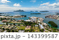 An industrial shipping port filled with containers, cranes, and cargo ships by the waterfront. Victoria. Seychelles, Mahe. 143399587
