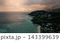 Beautiful sunset casting orange hues over multiple islands and calm ocean waters, with silhouetted hills. Seychelles, Mahe. 143399639