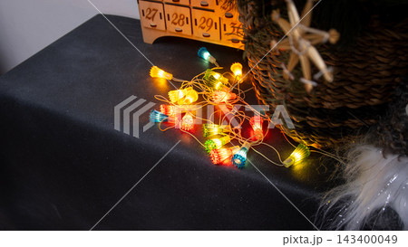 Vintage Christmas Lights Garland Glowing. Colorful String Lights on Dark Surface 143400049