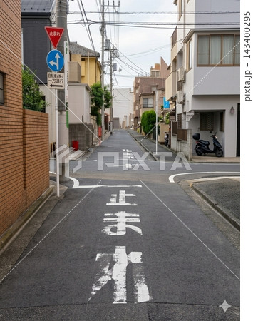 日本の住宅街の道路に描かれた、かすれた「止まれ」の文字と標識 日本の住宅街の道路に描かれた、かすれた「止まれ」の文字と標識 143400295