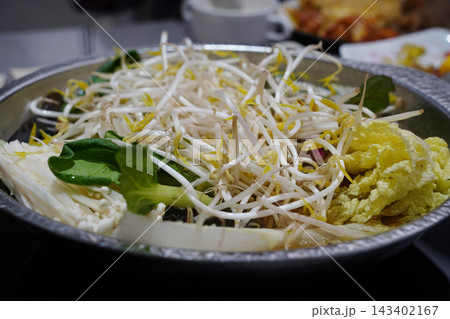 Hot pot or shabu-shabu pot filled with fresh cabbage, bean sprouts and mushrooms 143402167