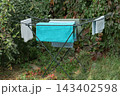 blue bucket hanging on a wall, hanging from a hose 143402598