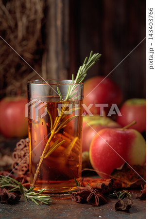 Apple juice on an old kitchen table next to fresh apples. 143403766