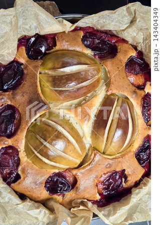 Freshly Baked Plum and Pear Cake on Parchment Paper for Autumn Dessert Freshly Baked Plum and Pear Cake on Parchment Paper for Autumn Dessert 143404349