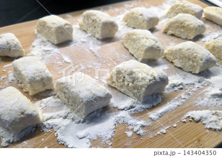 Homemade Gnocchi Preparation on a Floured Wooden Surface for Culinary Delight 143404350