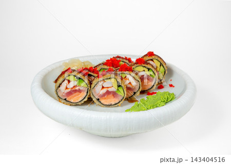 Crispy fried sushi roll with tuna, salmon, shrimp and avocado topped with red tobiko and unagi sauce on white plate, isolated on white background 143404516