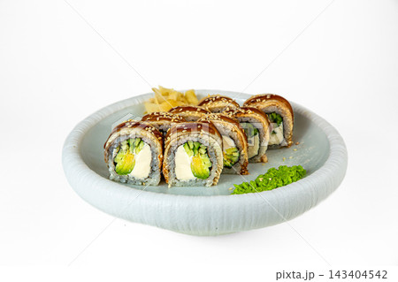 Sushi roll topped with eel, unagi sauce and sesame, filled with cream cheese, avocado and cucumber on white plate, isolated on white background Sushi roll topped with eel, unagi sauce and sesame, filled with cream cheese, avocado and cucumber on white plate, isolated on white background 143404542