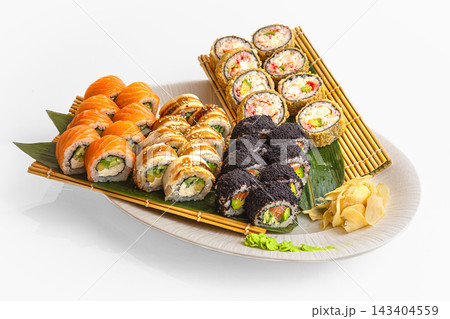 Large sushi set with salmon, eel, black tobiko and crab rolls on bamboo mat with pickled ginger, isolated on white background Large sushi set with salmon, eel, black tobiko and crab rolls on bamboo mat with pickled ginger, isolated on white background 143404559