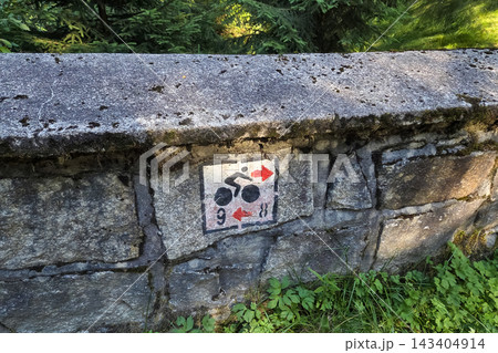 Bicycle Route Sign on Stone Wall in Forest Pathway Bicycle Route Sign on Stone Wall in Forest Pathway 143404914