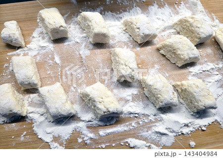 Homemade Gnocchi Preparation on Wooden Board for Italian Cuisine Enthusiasts Homemade Gnocchi Preparation on Wooden Board for Italian Cuisine Enthusiasts 143404984