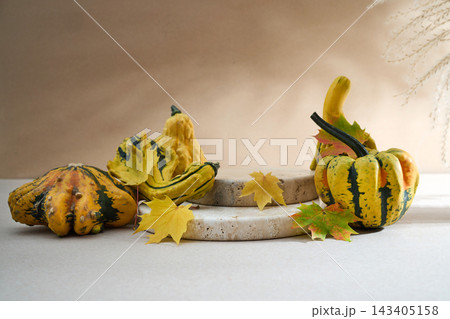 Autumn gourds and maple leaves on stone podium Autumn gourds and maple leaves on stone podium 143405158