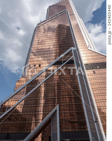 Modern glass skyscrapers with reflective facades rising against a clear blue sky in an urban setting Modern glass skyscrapers with reflective facades rising against a clear blue sky in an urban setting 143405440