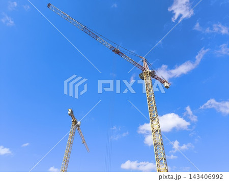 High-rise tower cranes against a blue sky 143406992