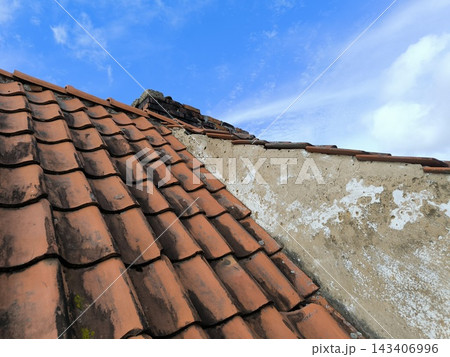 Old tiled roof with a textured wall 143406996