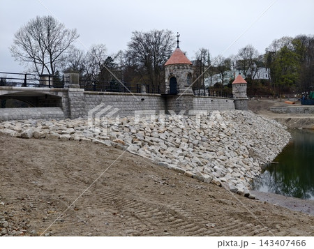 Tranquil reservoir bordered by historic masonry. Peaceful waterscape with aged stone and modern repair work Tranquil reservoir bordered by historic masonry. Peaceful waterscape with aged stone and modern repair work 143407466