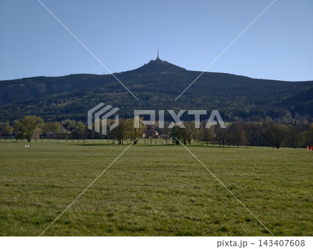 Sunlit mountains with colorful surroundings. Charming village amid lush wooded hills under evening sun Sunlit mountains with colorful surroundings. Charming village amid lush wooded hills under evening sun 143407608