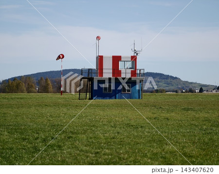 Idyllic countryside setting showcasing windsock tower alongside peaceful farmland and control unit Idyllic countryside setting showcasing windsock tower alongside peaceful farmland and control unit 143407620