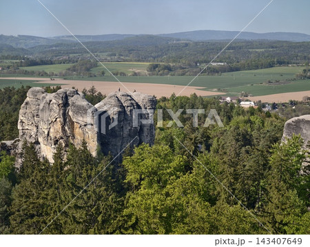 Cliff edges painted. Eroded cliff with foliage on rim overlooks patchwork farmland and faroff lush valley Cliff edges painted. Eroded cliff with foliage on rim overlooks patchwork farmland and faroff lush valley 143407649