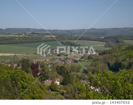 Scenic village seen from elevated vantage point. Panoramic scene of countryside with fields and woods Scenic village seen from elevated vantage point. Panoramic scene of countryside with fields and woods 143407658