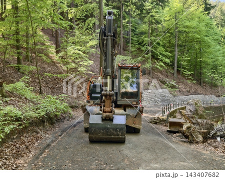 Heavy machinery working diligently to establish and secure rural forest pathway for access and preservation 143407682